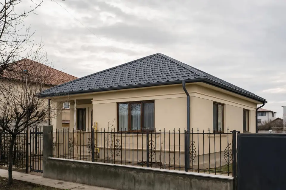 Aceeași casă cu acoperiș nou din țiglă metalică și jgheaburi noi — după (imagine ilustrativă)